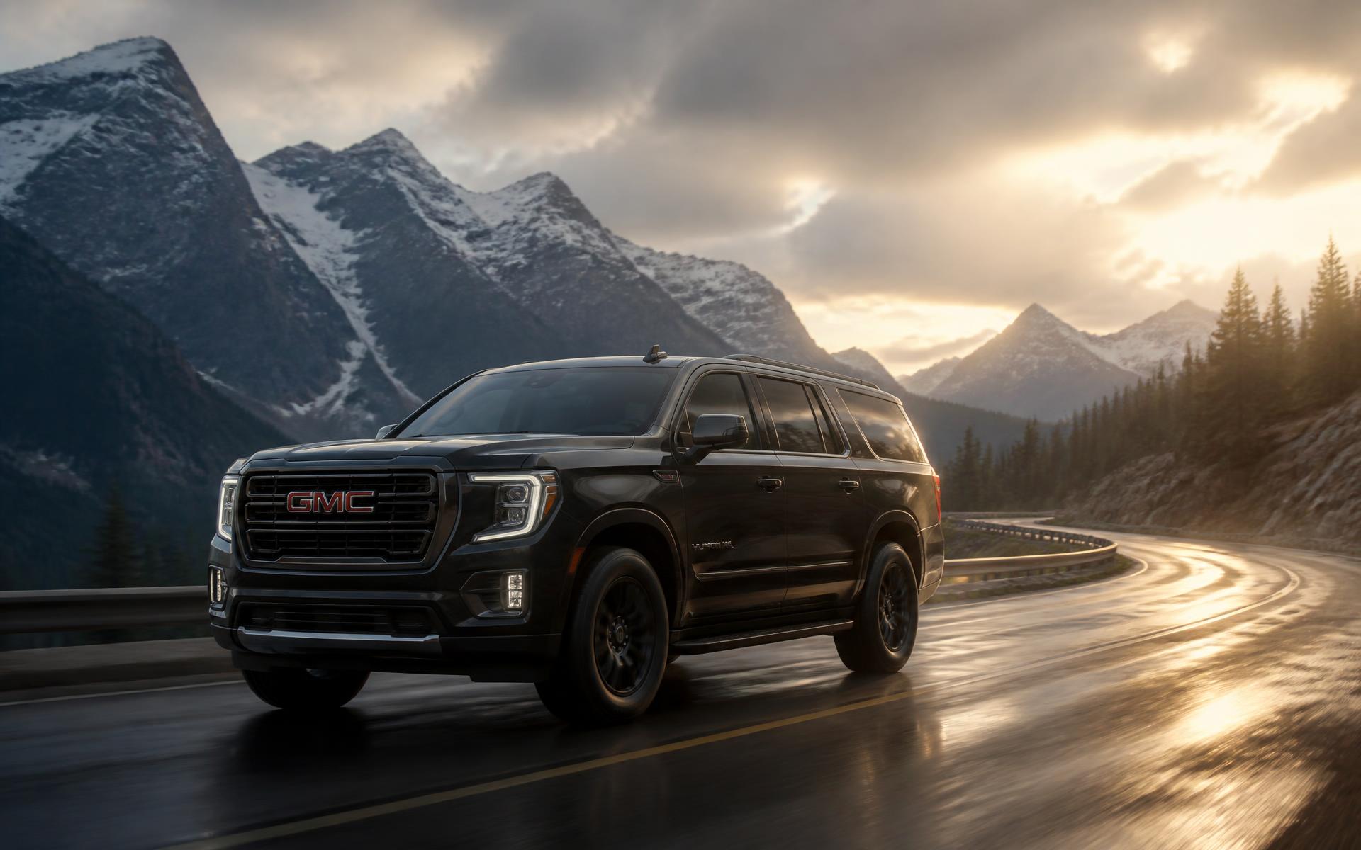 Black GMC Yukon XL on a wet mountain highway near Banff at golden hour